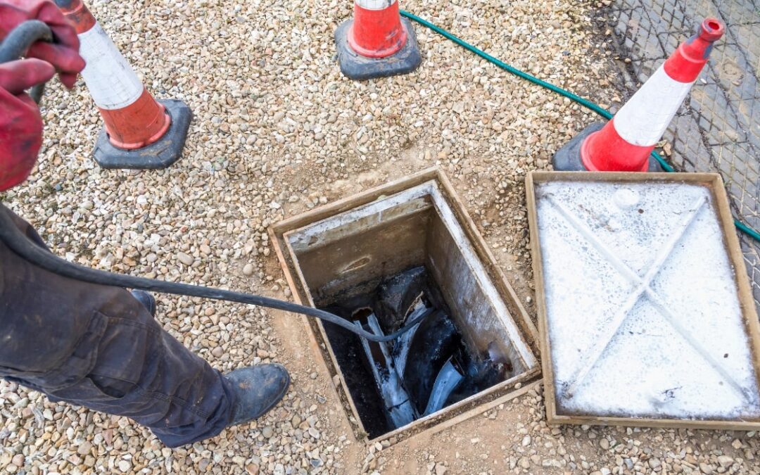 2 men cleaning a drain line for a business