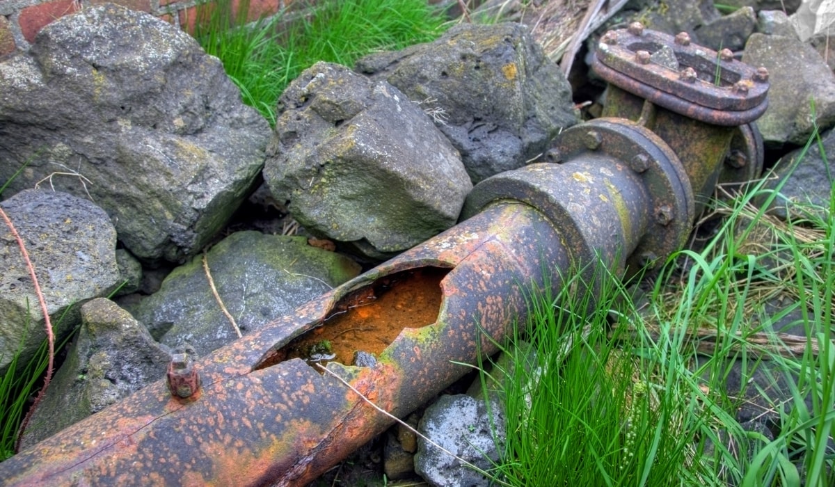 old cast iron pipes-min old, rusted and split, cast iron pipe