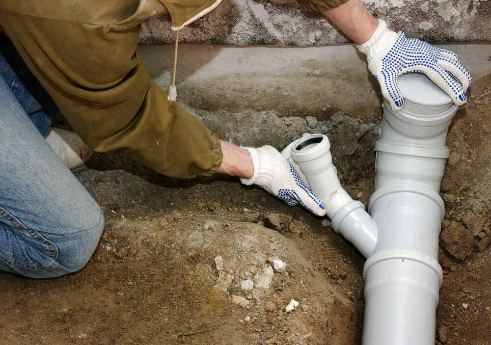 Plumber assembling PVC sewage pipes